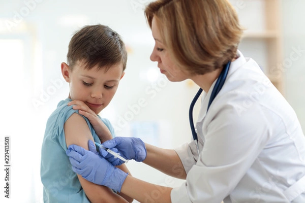 Fototapeta Brave child boy receiving injection or vaccine with a smile