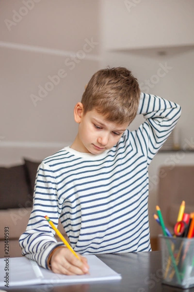Fototapeta Portrait of a boy doing homework