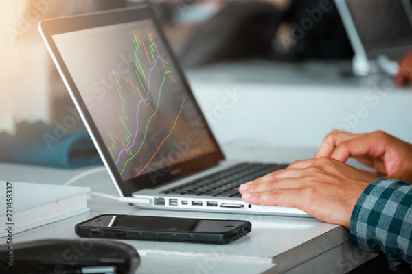 Fototapeta Close up of man using laptop trading stock exchange market in coffee cafe