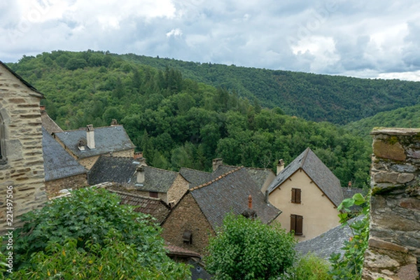 Obraz View of slate roofs old house in a french village. Green mountain in the background