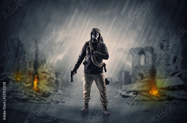 Fototapeta Destroyed place after a catastrophe with man in gas mask and weapon on his hand
