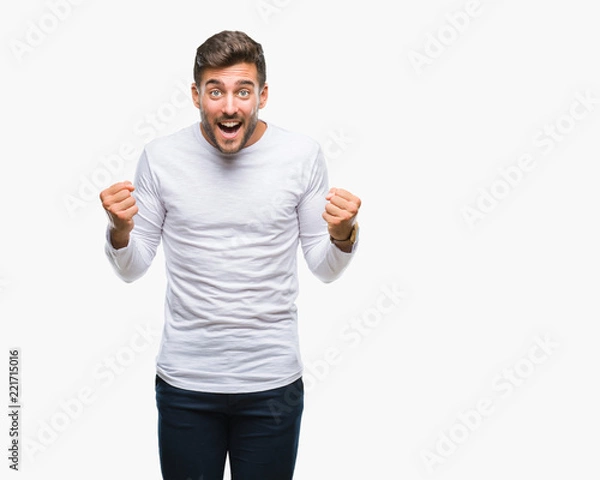 Fototapeta Young handsome man over isolated background celebrating surprised and amazed for success with arms raised and open eyes. Winner concept.