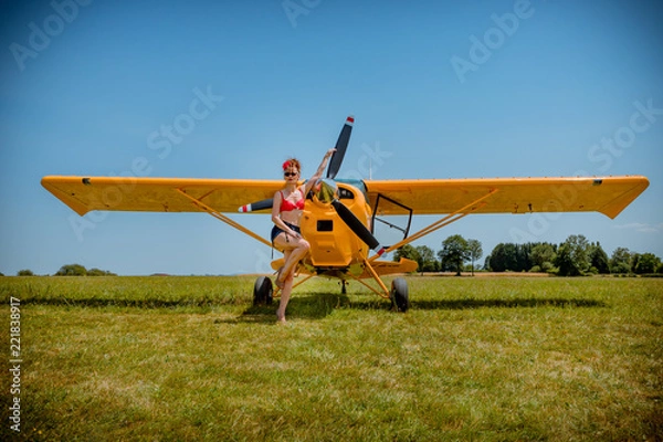 Fototapeta La Pinup devant l'avion jaune
