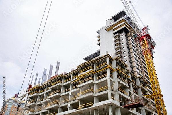 Fototapeta inside building sites under construction and cranes with blue sky background. unfinished cement building at construction site.
