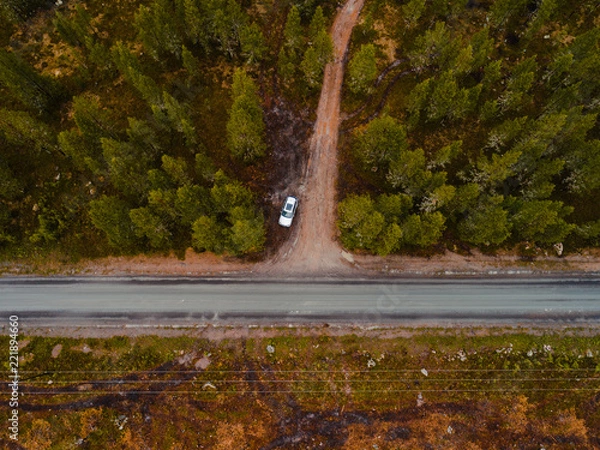 Fototapeta Finland, aerial view of a car parked by the side of the road in the forest of Lapland