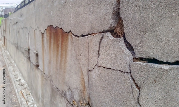 Fototapeta Cracks and chips on the ruined foundation of the old building structure