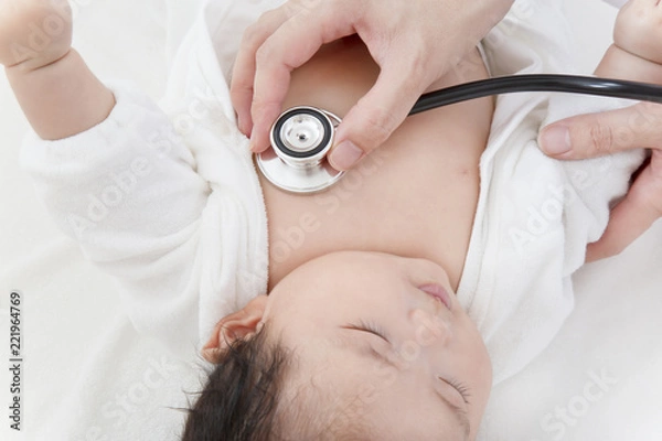Obraz 病院で胸に聴診器を当て診察を受ける新生児の赤ちゃん。子供の健康診断、健診,定期健診,診察,病気イメージ