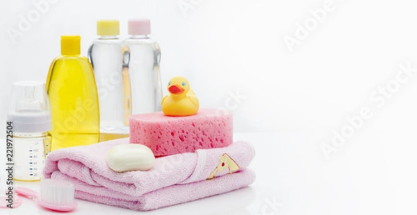 Obraz Still life with baby hygiene and bath items, shampoo bottle, essential oil, baby soap, towel, pacifier, rubber toy, shower puff. Copy space for your text