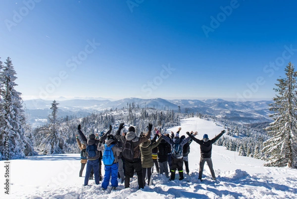 Obraz Grupa ludzi stoi zimą na szczycie góry