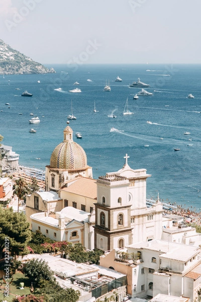 Obraz The coast of Positano, Amalfi in Italy. Panorama of the evening city and the streets with shops and cafes. Houses by the sea and the beach. Ancient architecture and temples