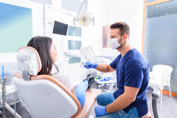 Obraz Młody dentysta leczy pacjentkę w gabinecie stomatologicznym