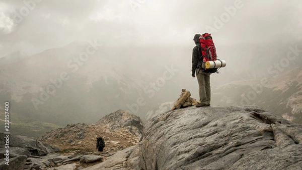 Obraz Trekking trip trough cloudy mountains in a foggy morning / Backpacking in Patagonia on a misty day with copy space for text