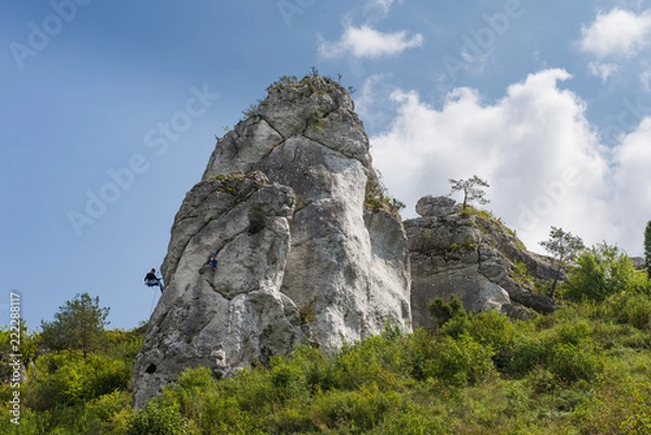 Fototapeta Climbing on the Jurassic rock. An atmospheric view of Jura. Blue sky and clouds.