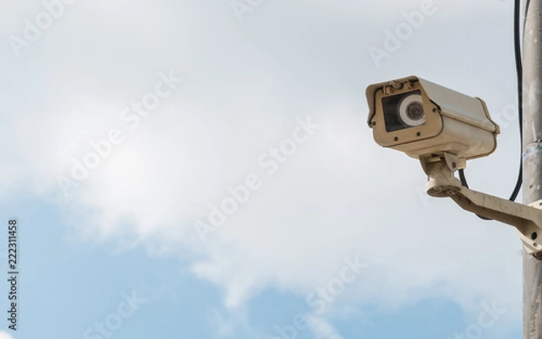 Obraz closed-circuit camera on white clouds background, closed-circuit camera on electric pole,
