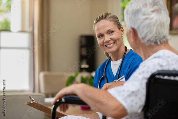 Fototapeta Przyjazna pielęgniarka rozmawia ze starszym pacjentem