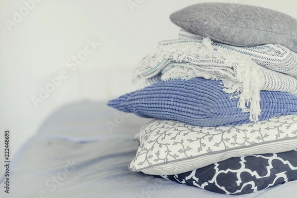 Obraz pile of pillows on the edge of the bed, in gray, monochrome