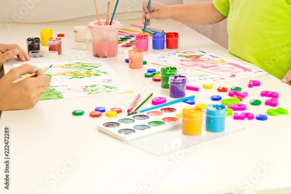 Fototapeta Children paint with gouache, paints , pencils. Mobile and entertainment Board games for children.Ceramic dishes in working process. Creating color patterns.