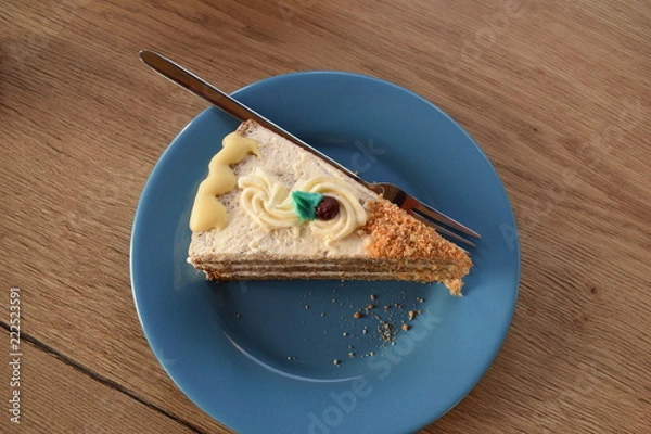 Fototapeta an appetizing slice of a pie made of banana and chocolate with a blue leaf on top and a cranberry on an emerald plate