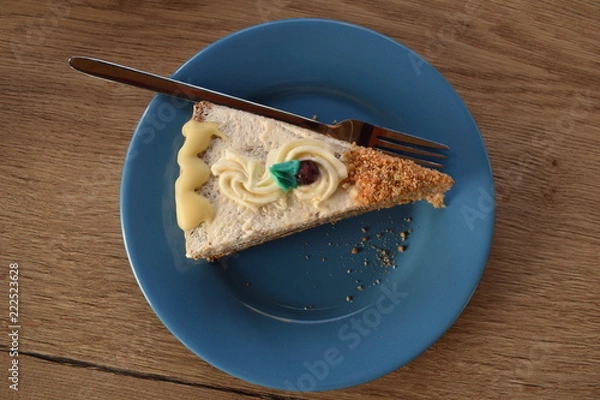 Fototapeta an appetizing slice of a pie made of banana and chocolate with a blue leaf on top and a cranberry on an emerald plate