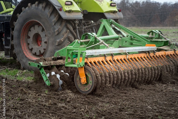 Fototapeta The disk harrow. Tractor blades for plowing land in the agriculture industry. Agricultural machinery for processing of the soil in the field.