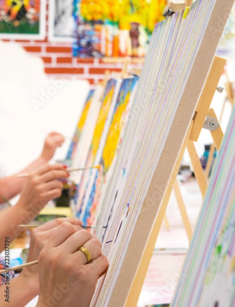 Fototapeta Women drawing on canvases during masterclass in the art studio, hands only