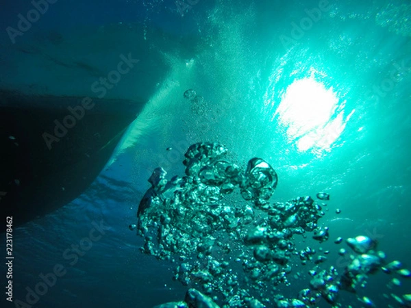 Fototapeta Air Bubbles Going up to the Surface  towards the Sun and the Dive Boat in the Red Sea in Egypt