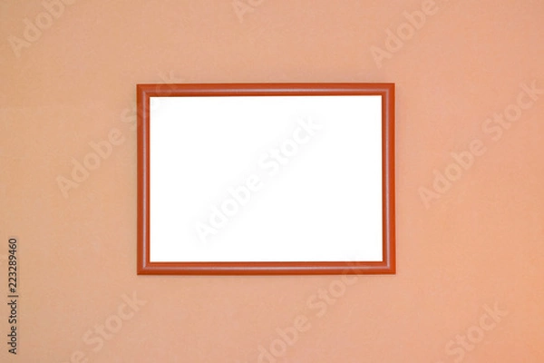 Fototapeta Wooden picture frame with blank white space for text on orange blurred background
