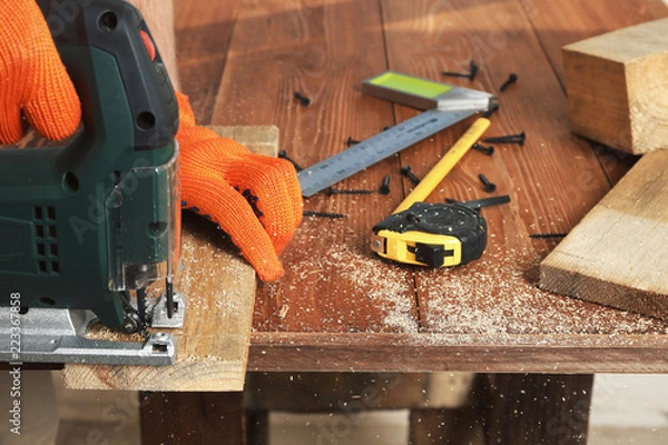 Obraz sawing a board with electric jigsaw