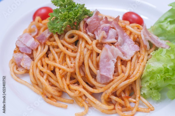 Fototapeta close up of delicious spaghetti with bacon and tomatoes on white plate and , Select focus