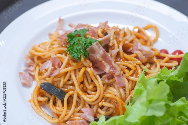 Fototapeta close up of delicious spaghetti with bacon and tomatoes on white plate and , Select focus