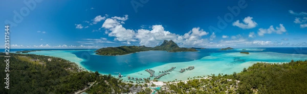 Fototapeta Panoramiczny widok z lotu ptaka na luksusowe wille nad wodą z palmami, błękitną laguną, białą piaszczystą plażą i górą Otemanu na wyspie Bora Bora, Tahiti, Polinezja Francuska (Bora Bora Aerial)