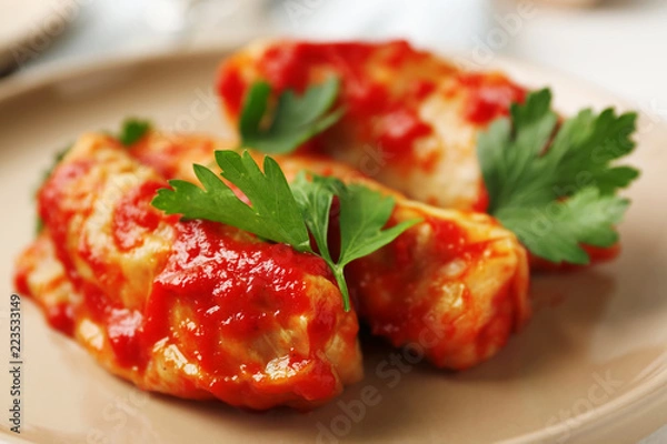 Fototapeta Stuffed cabbage leaves in tomato sauce on plate, closeup