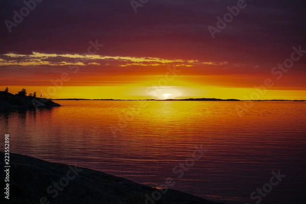 Fototapeta The setting sun on the Island of Aspö in Archipelago National Park (Skärgårdshavet nationalpark), Finland, 4 days after the summer solstice.