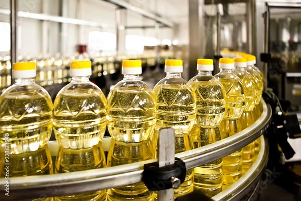 Fototapeta Sunflower oil in the bottle moving on production line. Shallow dof.