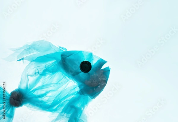 Fototapeta Fish from a plastic bag. Blue color, translucent. The concept of saving the environment, pollution of the oceans, seas and rivers. White background for copy space text