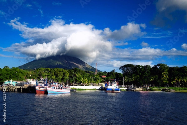 Fototapeta OMETEPE, NICARAGUA - Dec 2015: Moyogalpa port on Ometepe Island in Lake Nicaragua with fishing boats and cloud-topped Concepcion volcano in the background