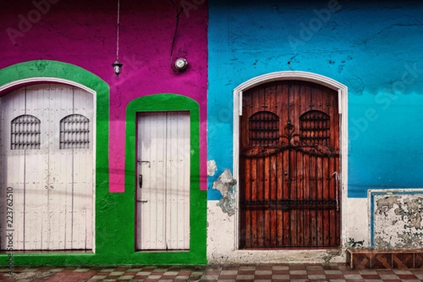 Fototapeta Three side-by-side colorful painted doorways with flaking paint and worn finish in the Colonial city of Leon in northern Nicaragua