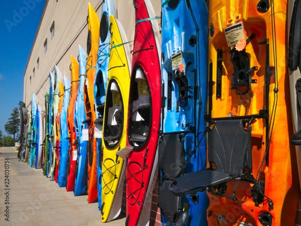 Obraz Colorful fiberglass kayaks on display outside sporting goods store in lake country of northern Minnesota