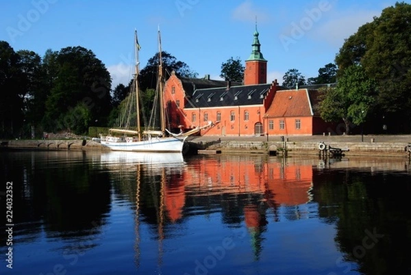Fototapeta Halmstad Castle (Halmstads slott), a 17th-century castle on the Nissan river in Halmstad, in the province of Halland, Sweden with a two-master moored in front