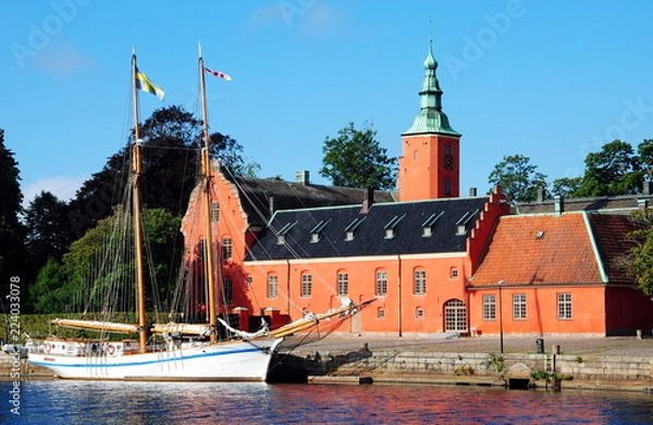 Fototapeta Halmstad Castle (Halmstads slott), a 17th-century castle on the Nissan river in Halmstad, in the province of Halland, Sweden with a two-master moored in front