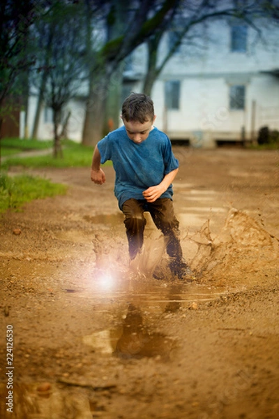 Fototapeta kid in puddle, splashing in puddle
