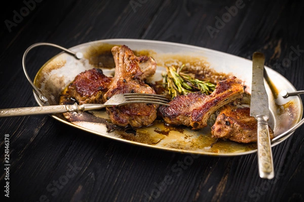 Obraz Lamb chops on a metal rustic plate with rosemary and spices