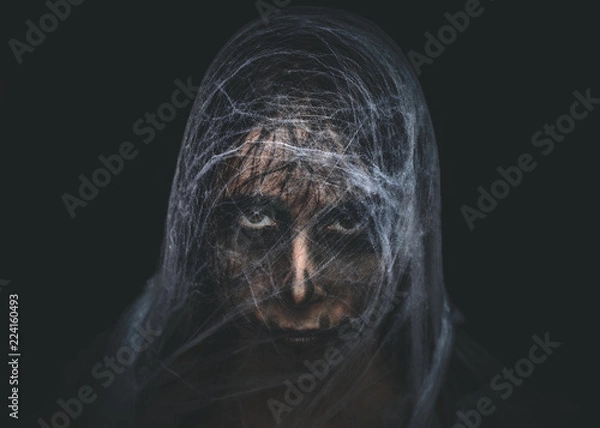 Fototapeta Spooky character covered with spiderweb on black background