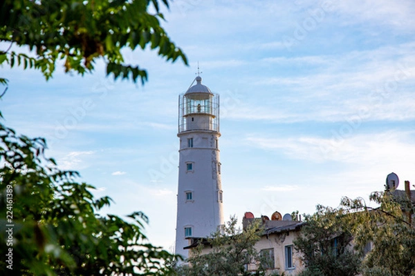 Fototapeta Lighthouse searchlight beam near ocean at day light Lighthouse in clear weather