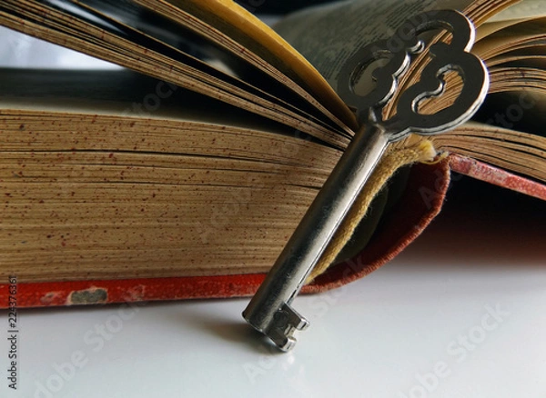 Fototapeta A key and an open old book