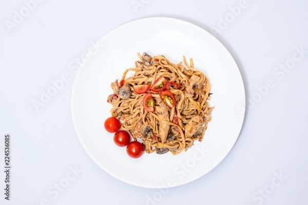 Fototapeta Wok food on a white ceramic plate is tasty and fresh with sauce on a light isolated background