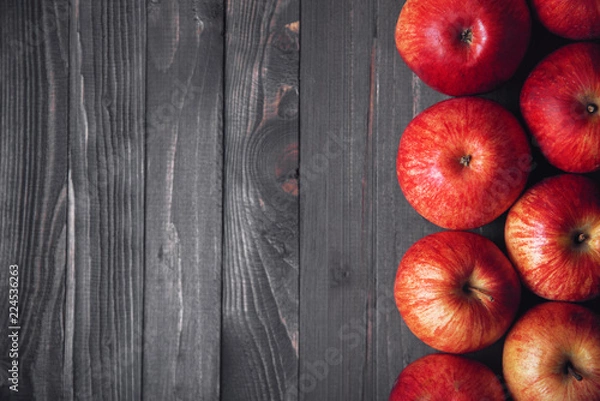Obraz Dark wooden background with red apples on the right side of the frame