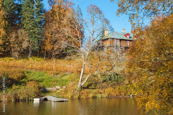Fototapeta Beach with a jetty and a house on the hill in autumn