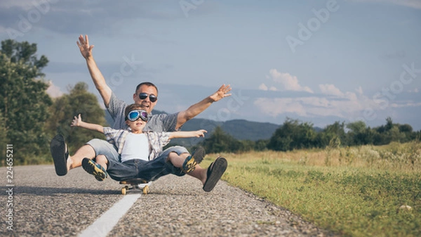 Obraz Ojciec i syn bawić się na drodze w czasie dnia.