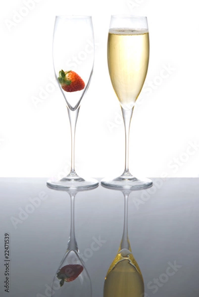 Fototapeta Two sparkling wine glasses with a strawberry
